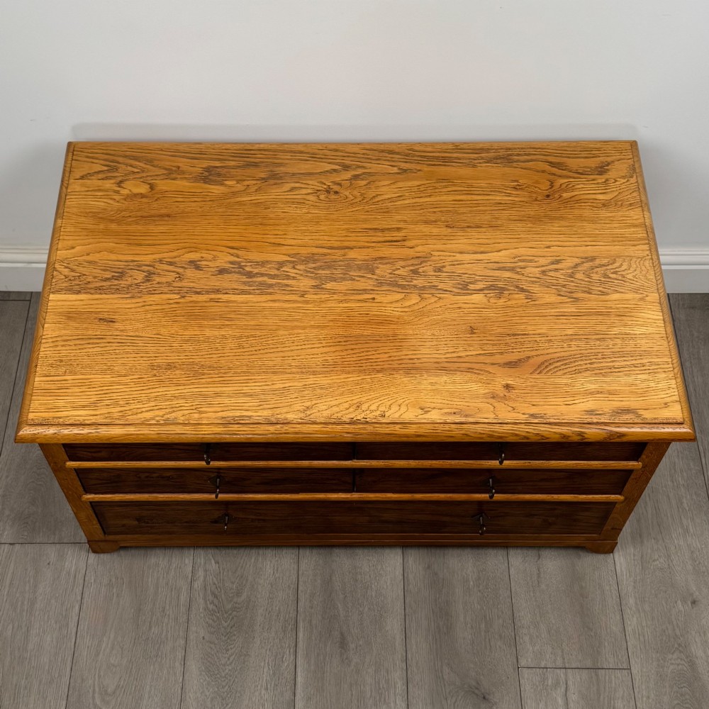A low 20th-century oak chest of drawers featuring five drawers arranged across three tiers with diamond-shaped metal handles. View IX