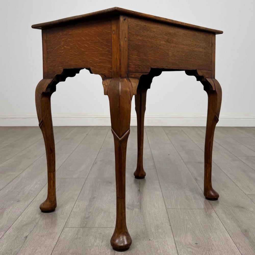 An 18th-century Georgian oak side table featuring a single drawer with geometric inlaid border, lion mask brass ring handles, shaped apron, and four cabriole legs ending in pad feet. View IV
