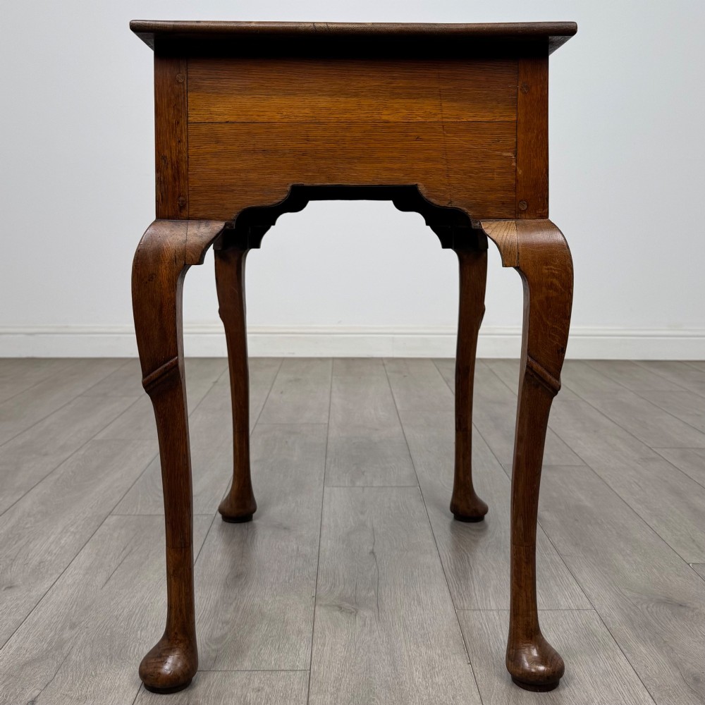 An 18th-century Georgian oak side table featuring a single drawer with geometric inlaid border, lion mask brass ring handles, shaped apron, and four cabriole legs ending in pad feet. View VII