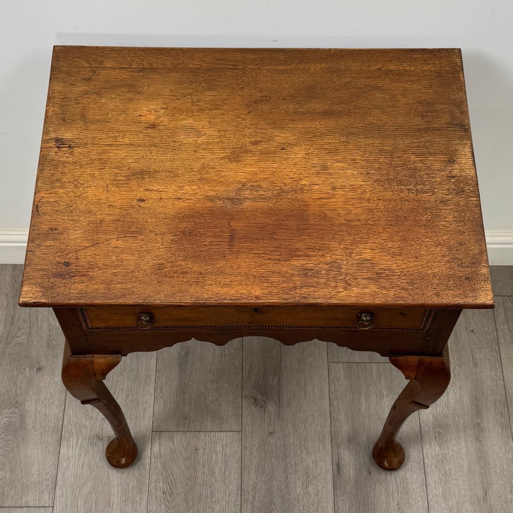 An 18th-century Georgian oak side table featuring a single drawer with geometric inlaid border, lion mask brass ring handles, shaped apron, and four cabriole legs ending in pad feet. View IX