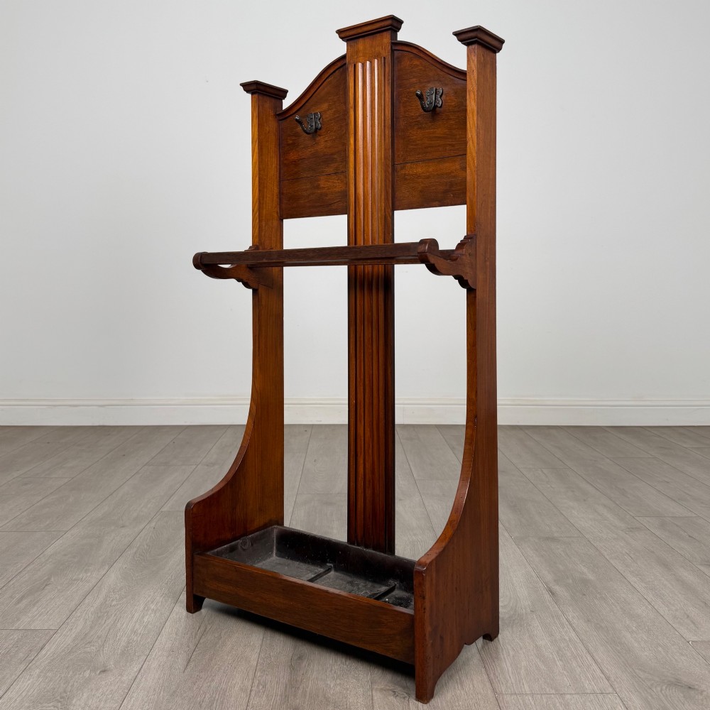 An Edwardian walnut hall stand featuring a fluted central column, metal coat hooks, a horizontal umbrella rail, and a metal drip tray at the base. View II