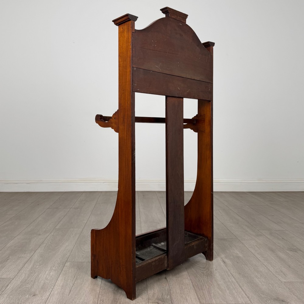 An Edwardian walnut hall stand featuring a fluted central column, metal coat hooks, a horizontal umbrella rail, and a metal drip tray at the base. View IV