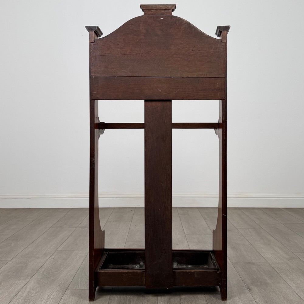 An Edwardian walnut hall stand featuring a fluted central column, metal coat hooks, a horizontal umbrella rail, and a metal drip tray at the base. View V