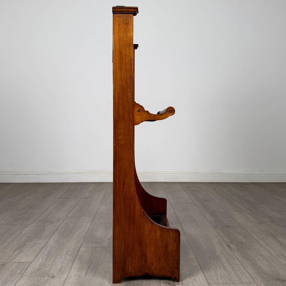 An Edwardian walnut hall stand featuring a fluted central column, metal coat hooks, a horizontal umbrella rail, and a metal drip tray at the base. View VII