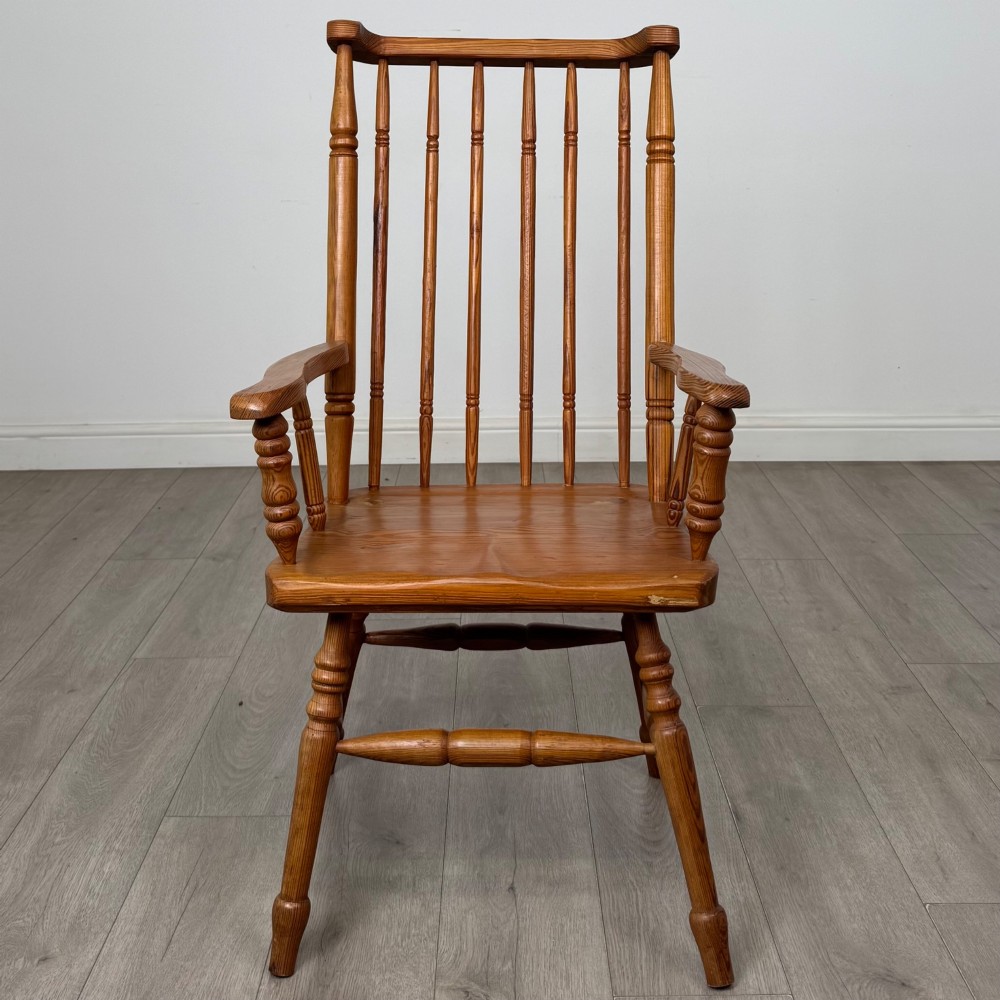 A twentieth-century pitch pine armchair featuring a tall stick back, sculpted armrests, and turned legs joined by stretchers. View VIII