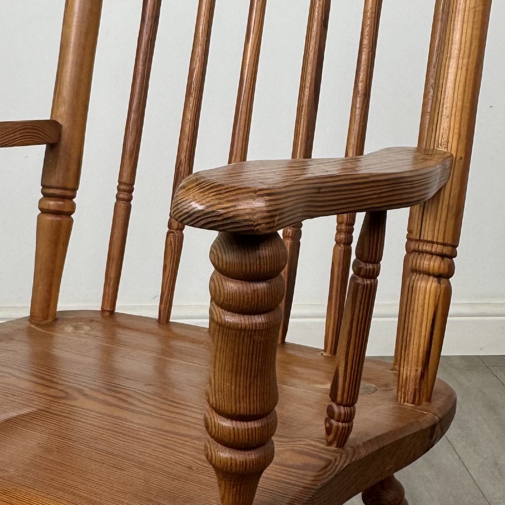A twentieth-century pitch pine armchair featuring a tall stick back, sculpted armrests, and turned legs joined by stretchers. View XI
