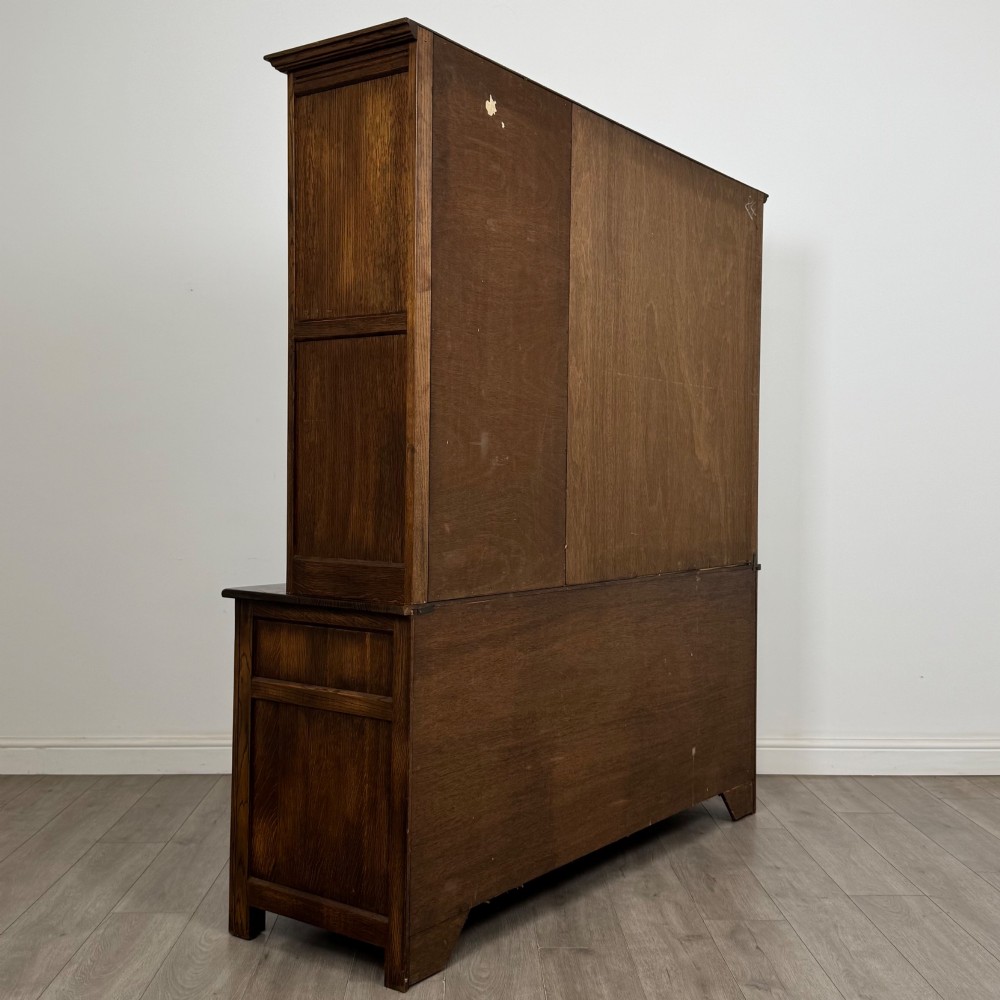 A large dark oak display cabinet featuring three leaded glass doors above three drawers and three panelled cupboard doors. View V
