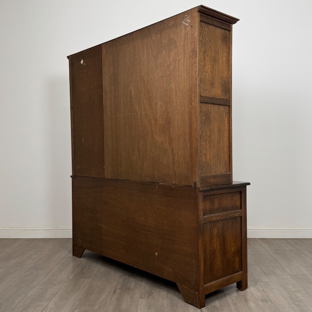 A large dark oak display cabinet featuring three leaded glass doors above three drawers and three panelled cupboard doors. View VII