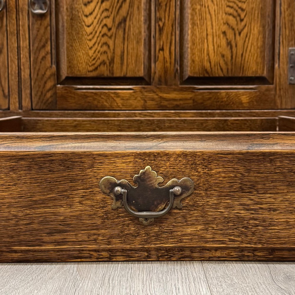 A large dark oak display cabinet featuring three leaded glass doors above three drawers and three panelled cupboard doors. View XII