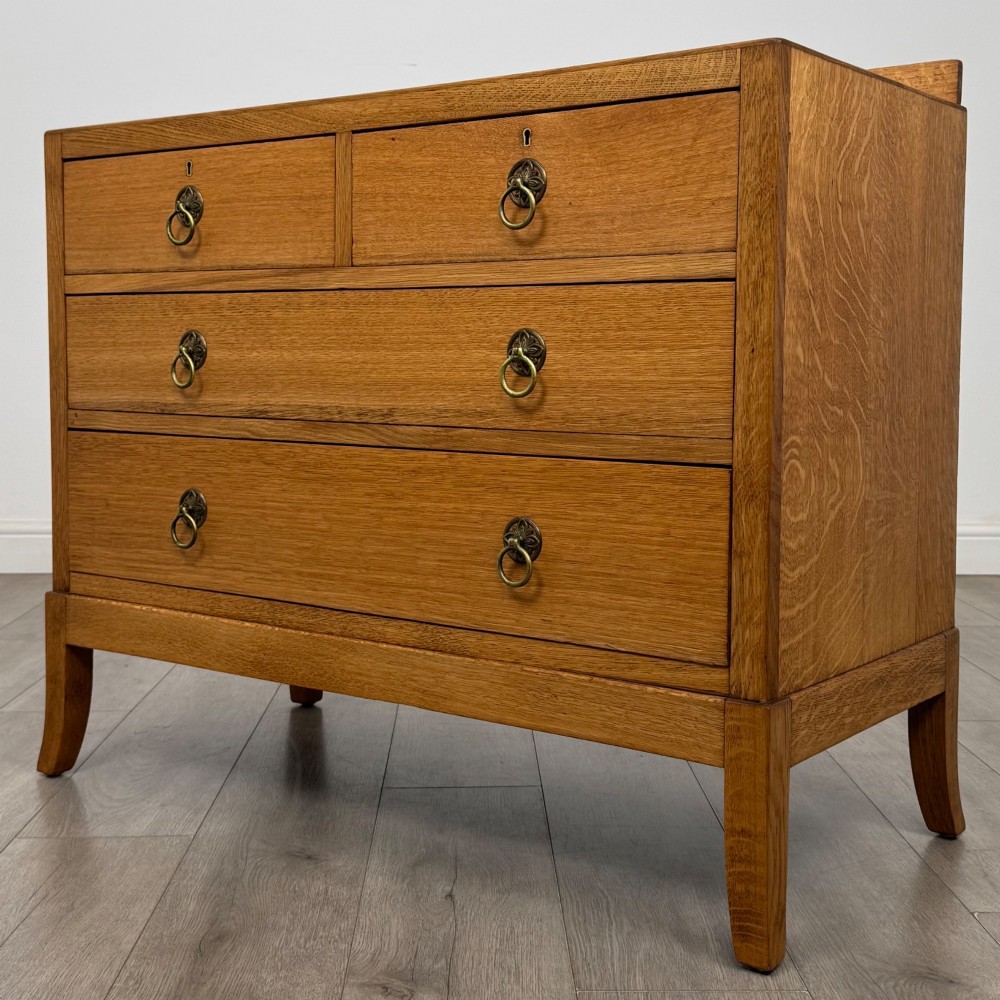 A golden oak chest of drawers featuring two short drawers over two long drawers with brass ring handles. View II