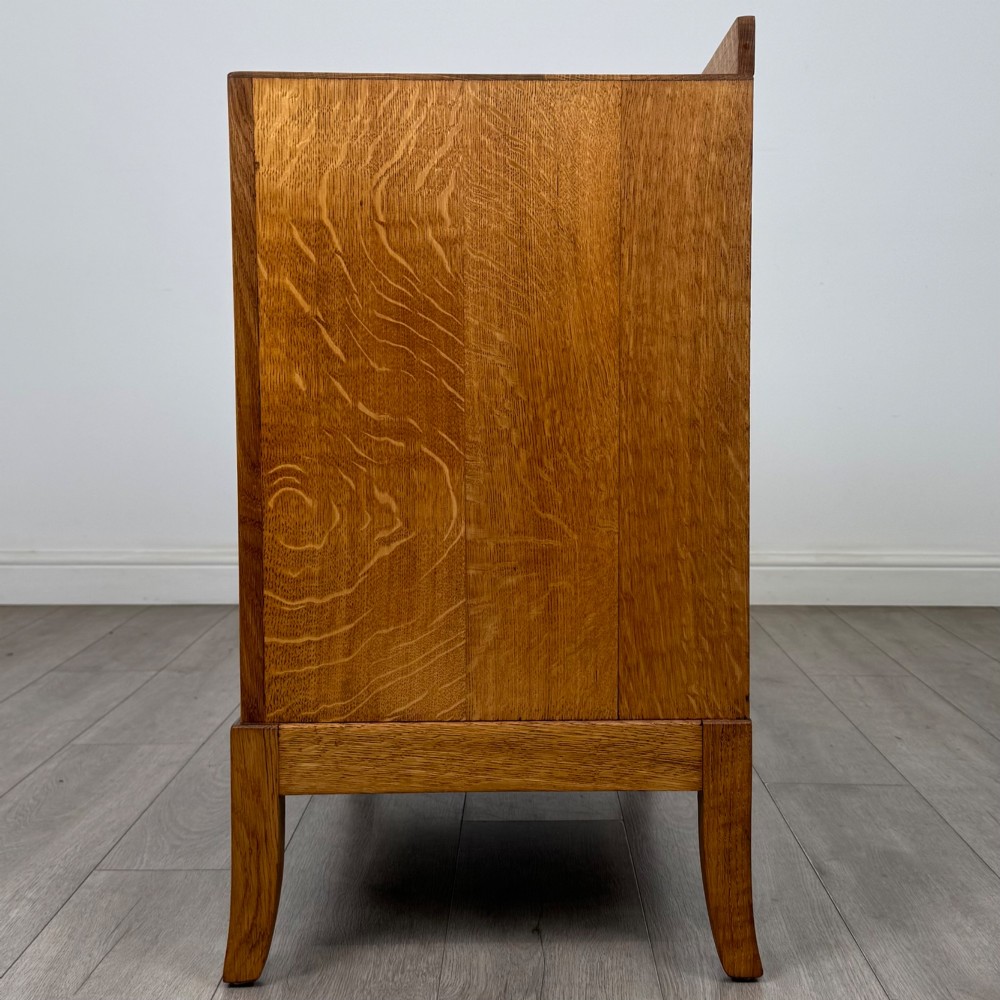 A golden oak chest of drawers featuring two short drawers over two long drawers with brass ring handles. View III