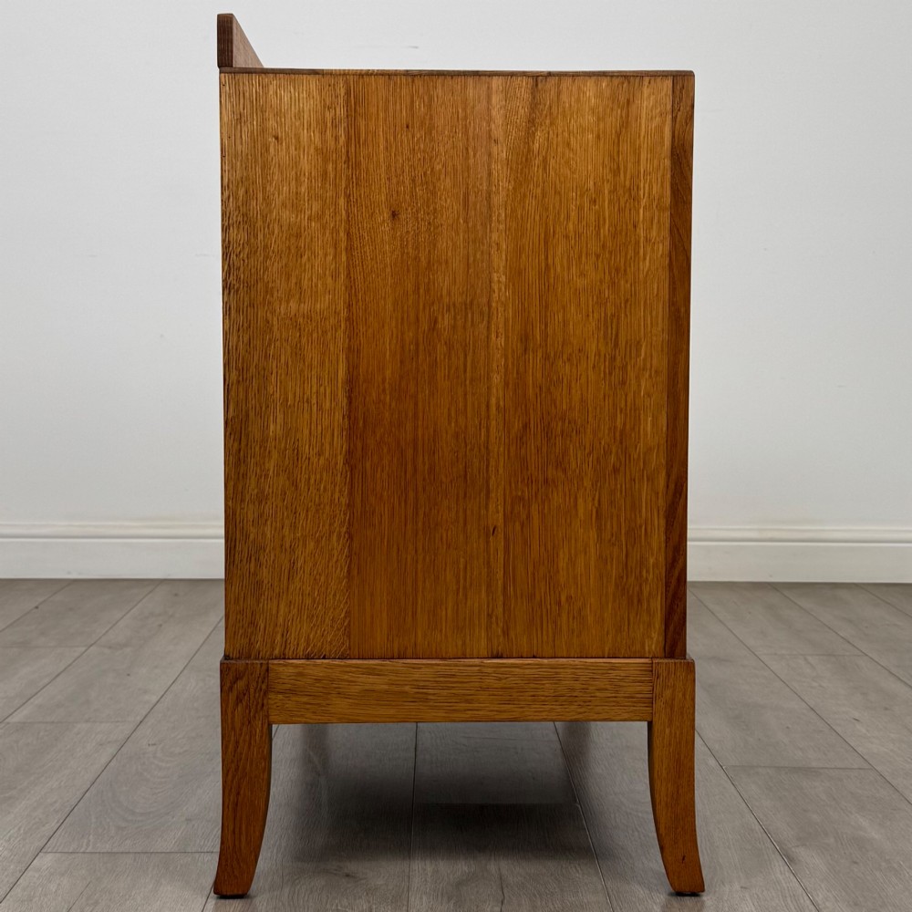 A golden oak chest of drawers featuring two short drawers over two long drawers with brass ring handles. View VII