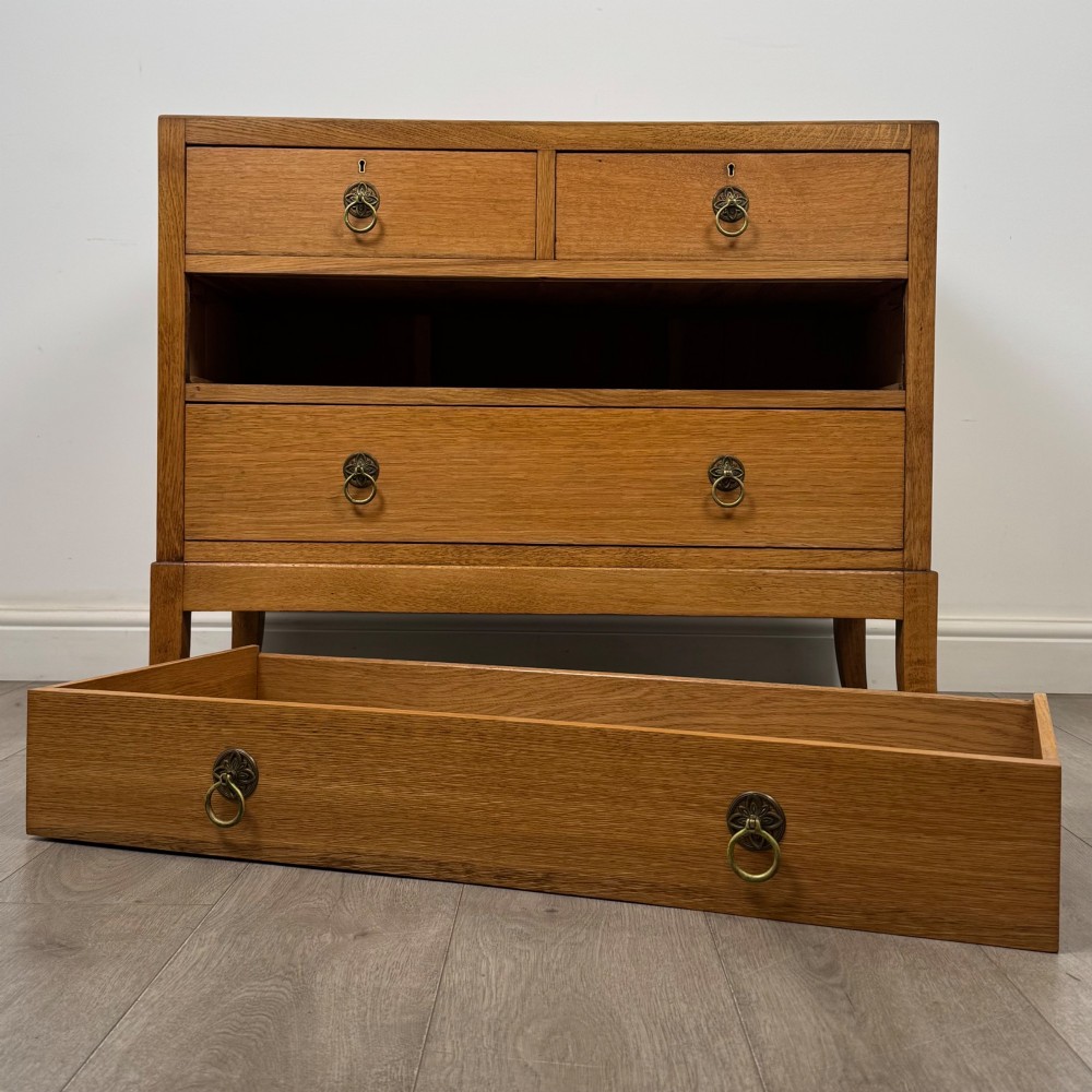 A golden oak chest of drawers featuring two short drawers over two long drawers with brass ring handles. View X