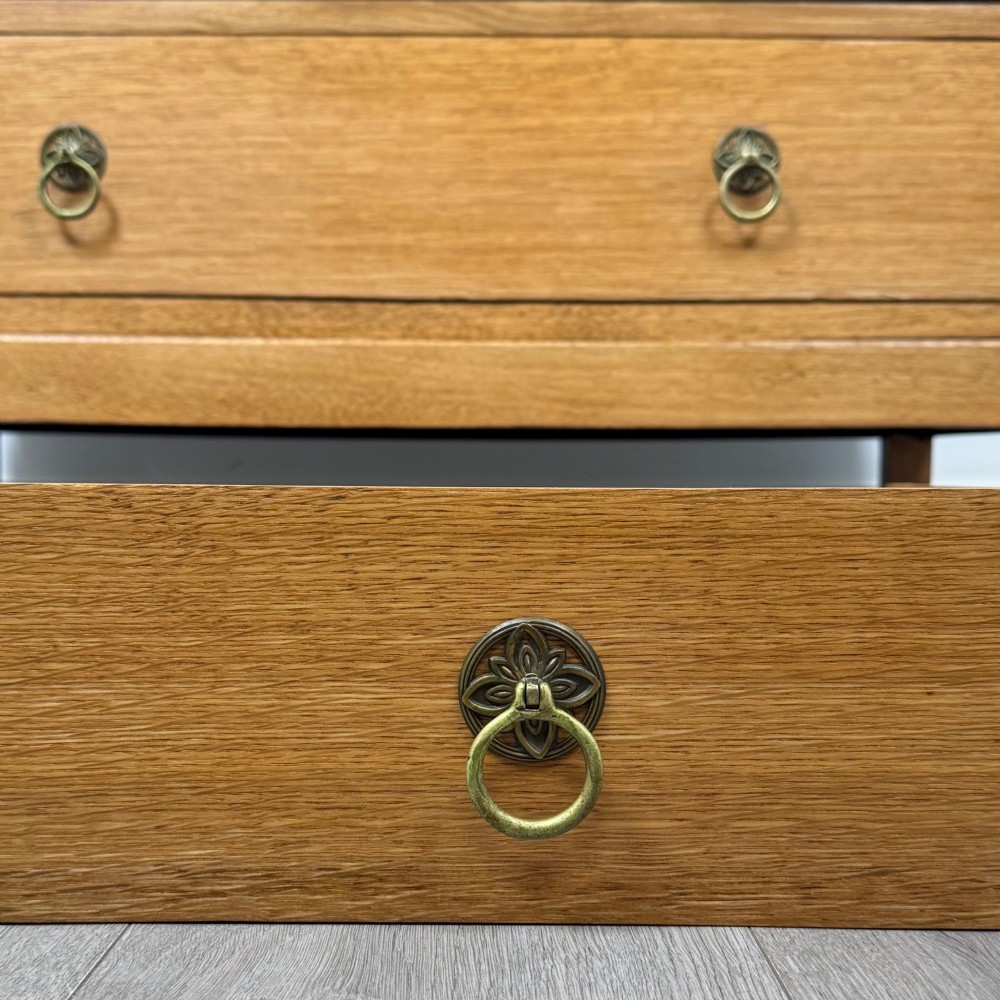 A golden oak chest of drawers featuring two short drawers over two long drawers with brass ring handles. View XI