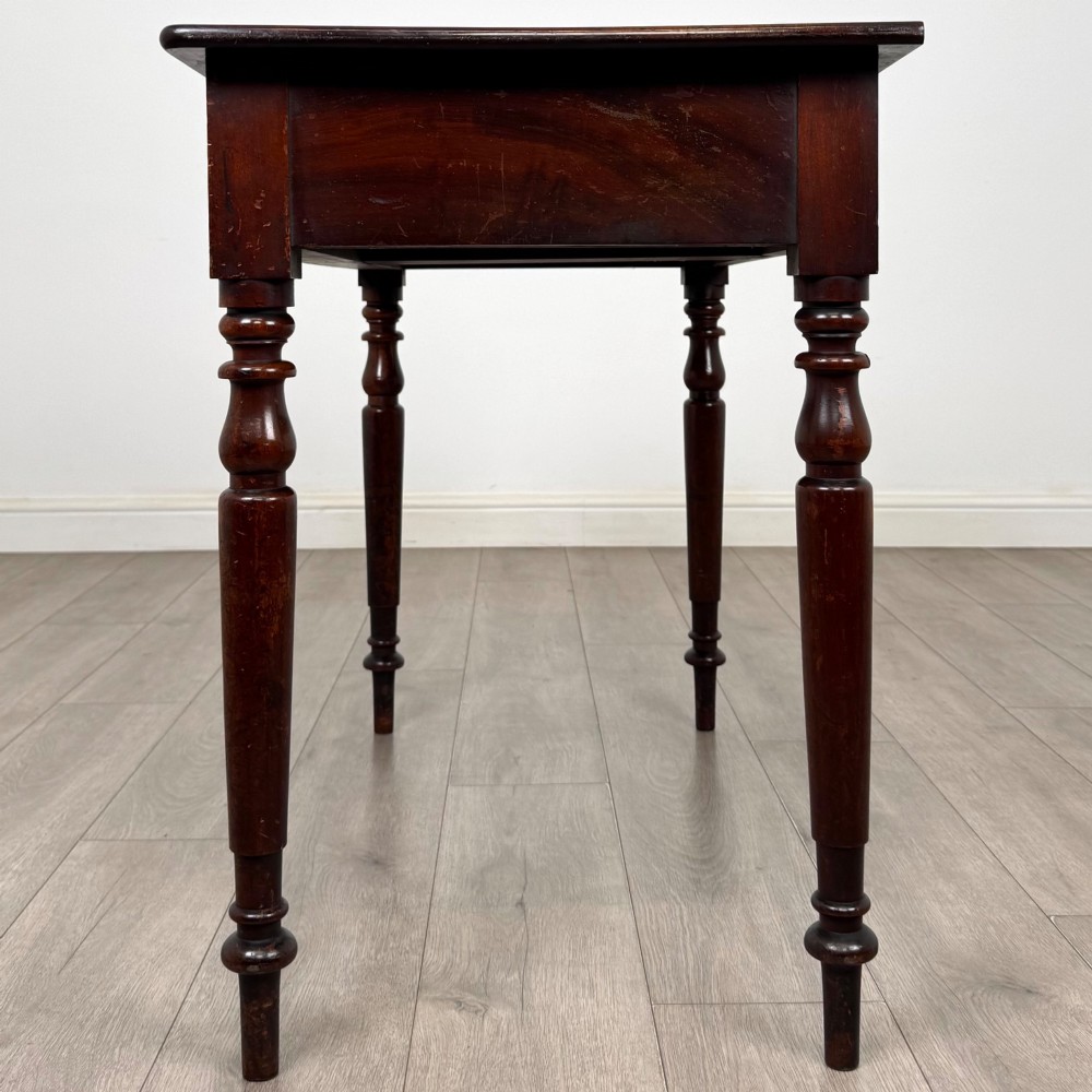 A Victorian dark mahogany writing table with two drawers, turned wooden knob handles, keyhole escutcheons, and four turned legs. View III