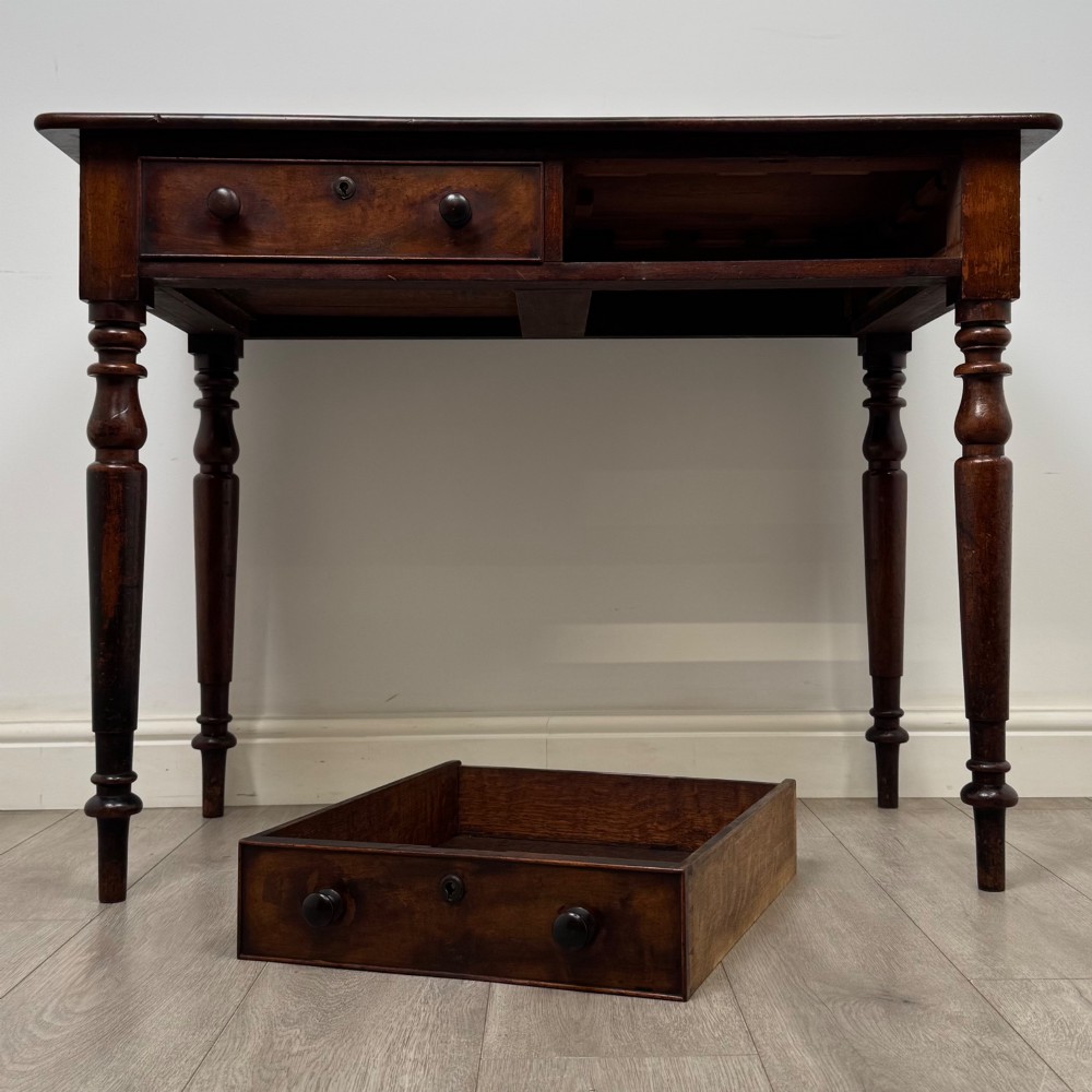 A Victorian dark mahogany writing table with two drawers, turned wooden knob handles, keyhole escutcheons, and four turned legs. View X