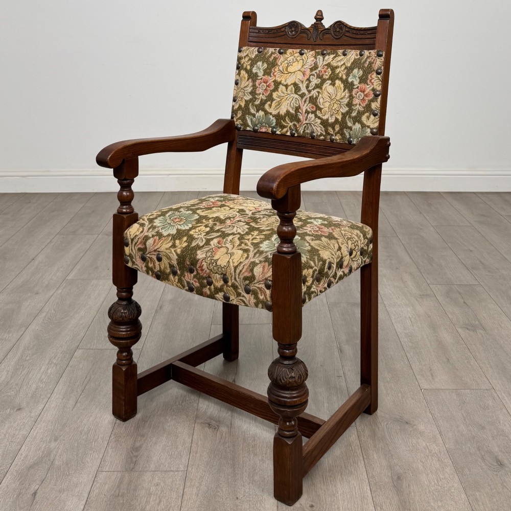 A set of six dark oak dining chairs with carved crest rails, floral tapestry upholstered backrests and seats, and turned front legs. View II