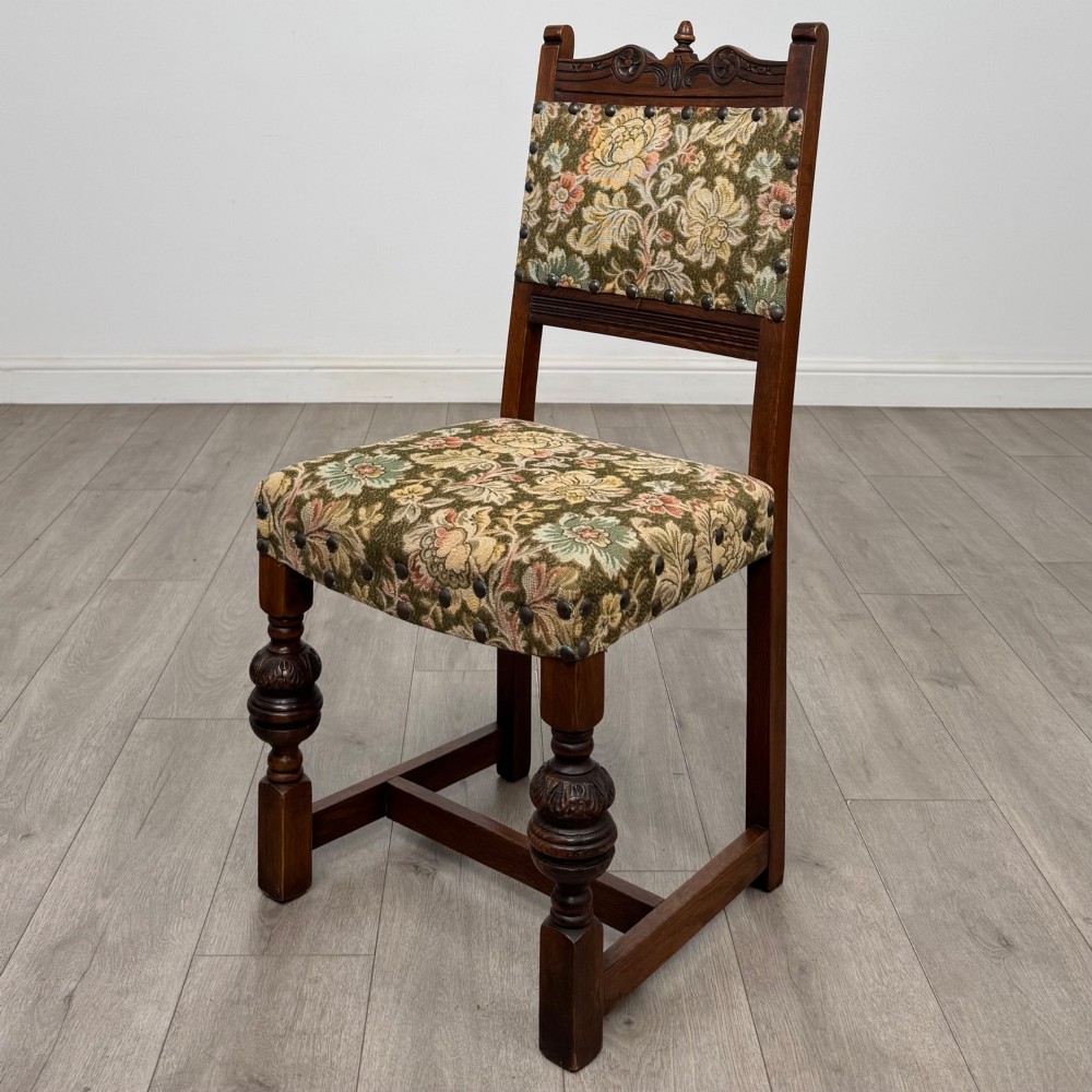 A set of six dark oak dining chairs with carved crest rails, floral tapestry upholstered backrests and seats, and turned front legs. View III