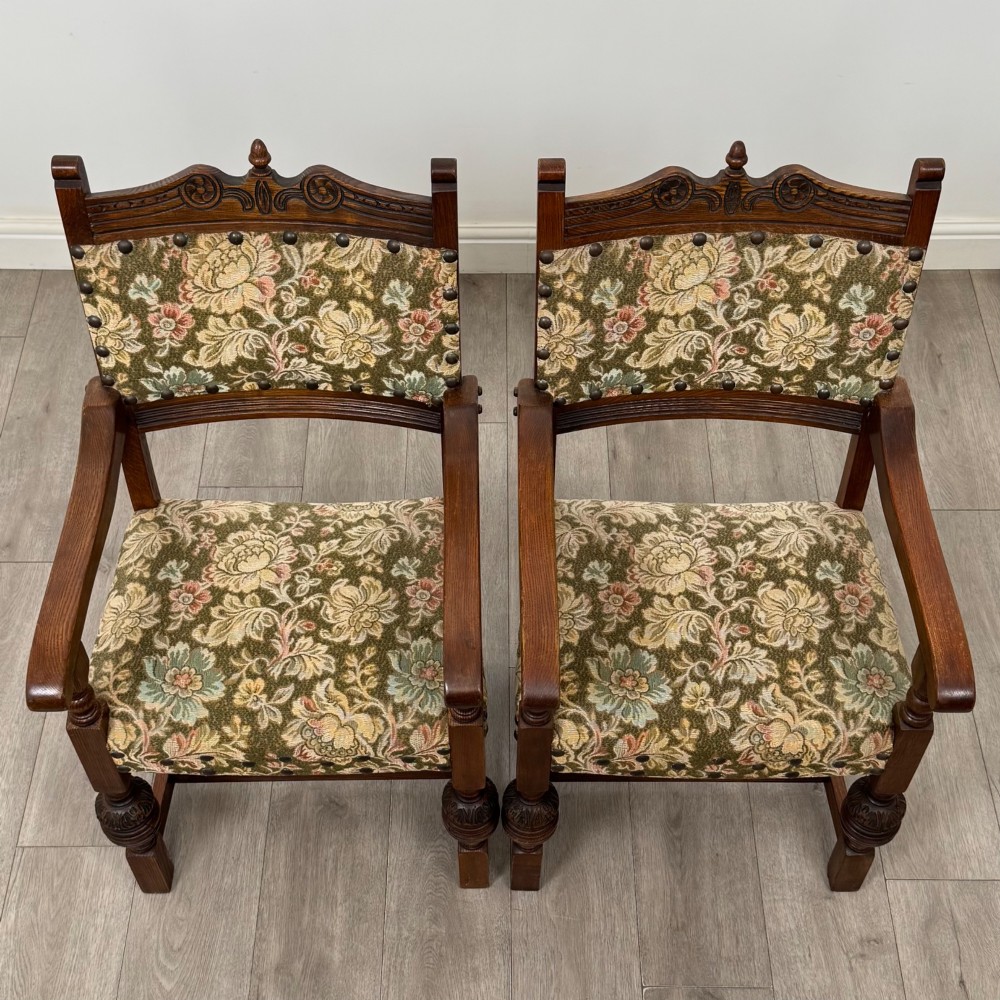 A set of six dark oak dining chairs with carved crest rails, floral tapestry upholstered backrests and seats, and turned front legs. View IX