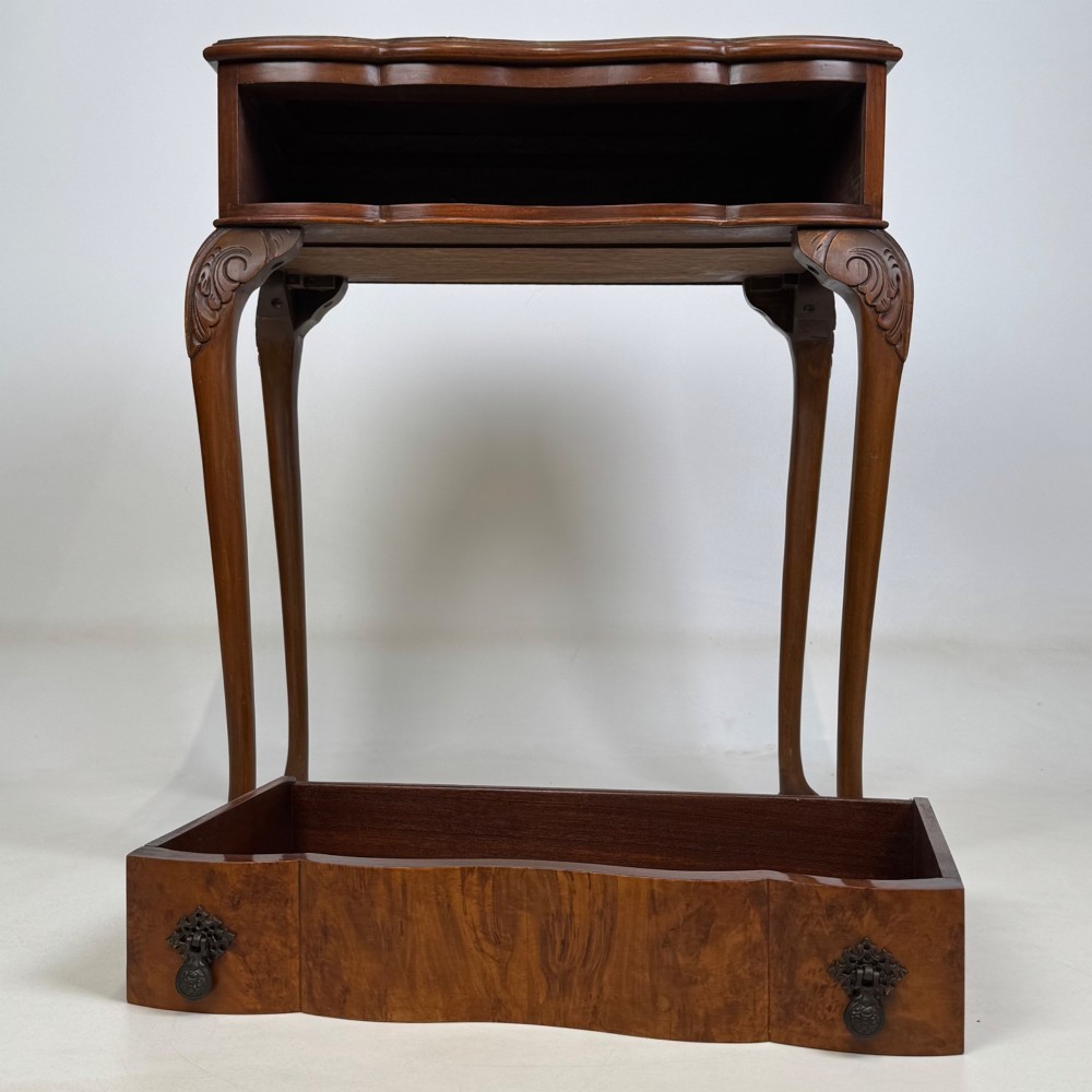 An Edwardian side table crafted from warm brown figured walnut featuring a single drawer with ornate brass handles and carved cabriole legs. View IX