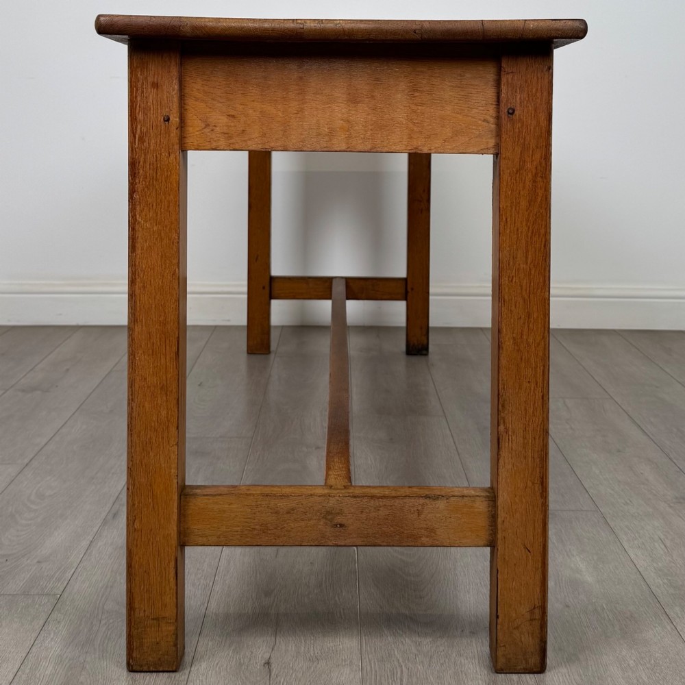 A long 20th century oak side table featuring a plain rectangular top, four square legs, and a low central stretcher. View III