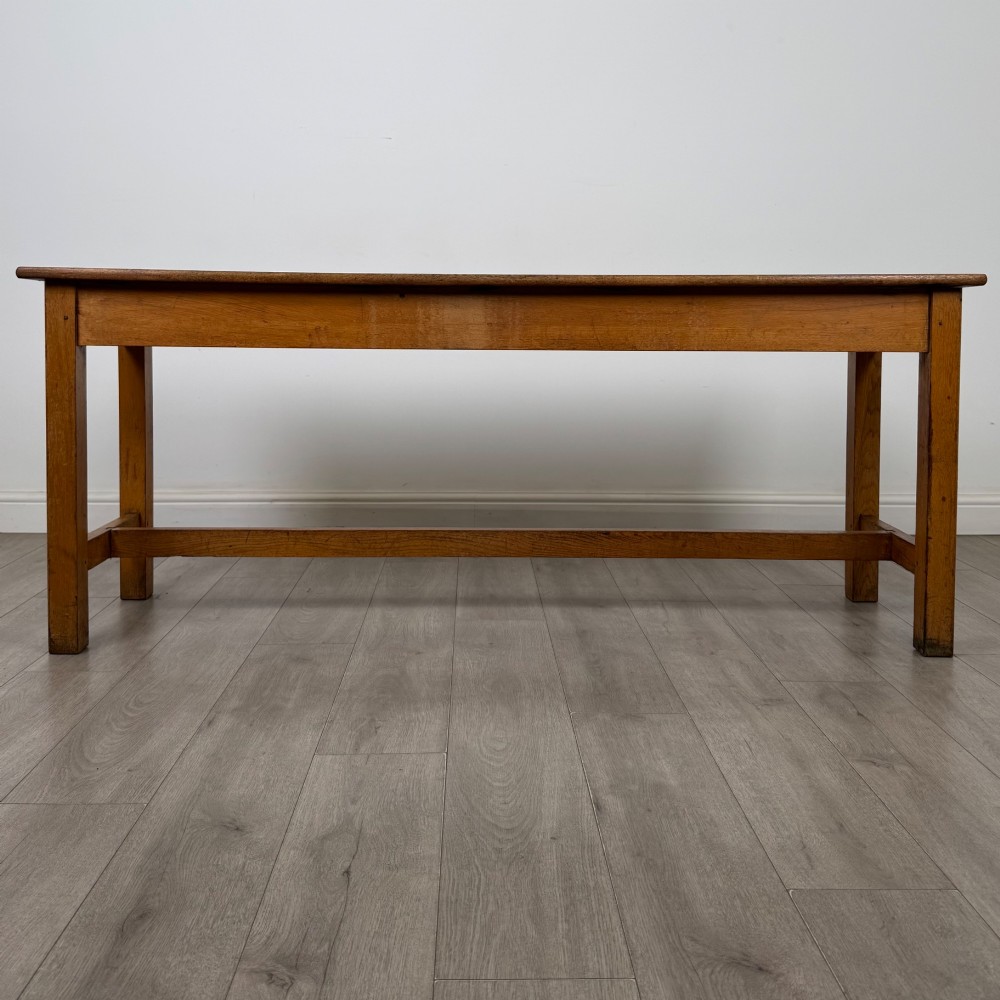 A long 20th century oak side table featuring a plain rectangular top, four square legs, and a low central stretcher. View V