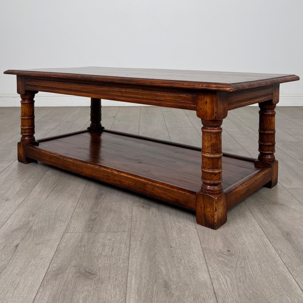 A low rectangular dark oak coffee table featuring turned legs and a solid lower shelf. View II