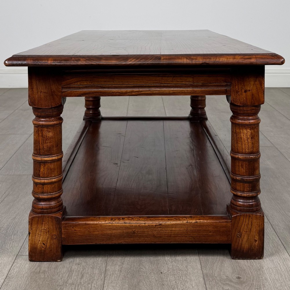 A low rectangular dark oak coffee table featuring turned legs and a solid lower shelf. View III