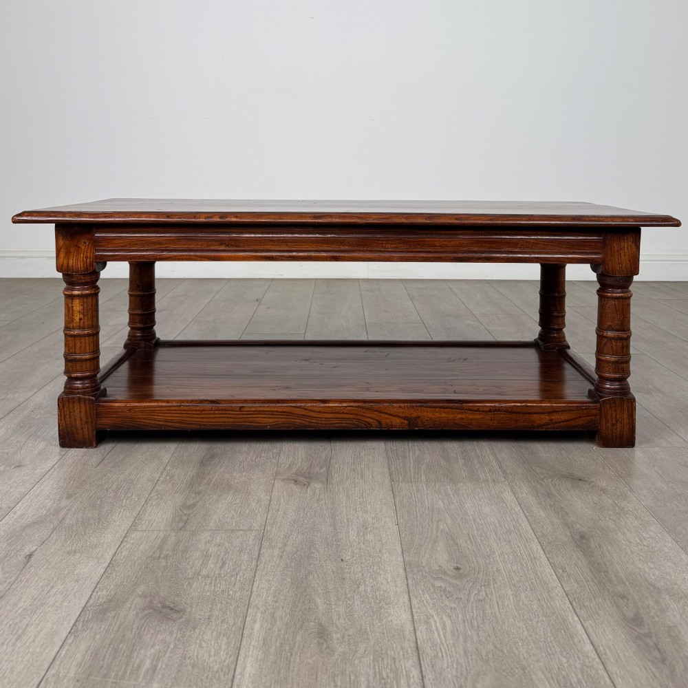 A low rectangular dark oak coffee table featuring turned legs and a solid lower shelf. View V