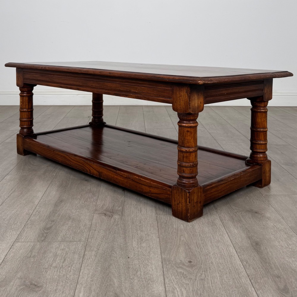 A low rectangular dark oak coffee table featuring turned legs and a solid lower shelf. View VI