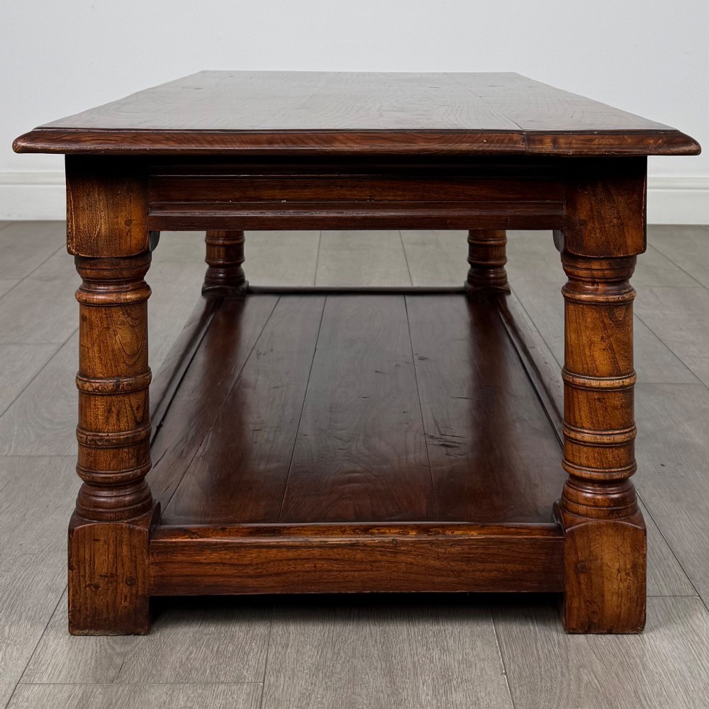 A low rectangular dark oak coffee table featuring turned legs and a solid lower shelf. View VII