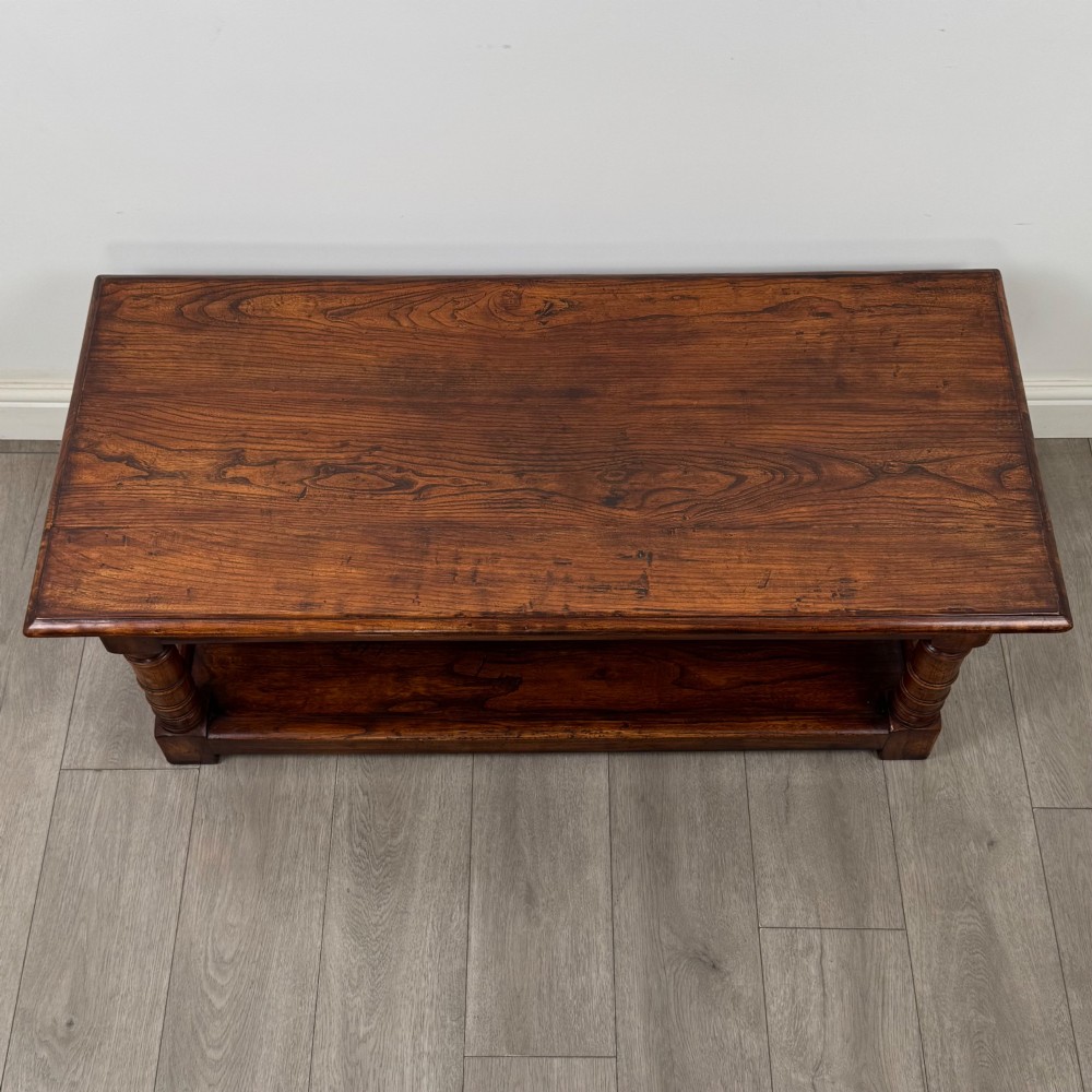 A low rectangular dark oak coffee table featuring turned legs and a solid lower shelf. View IX