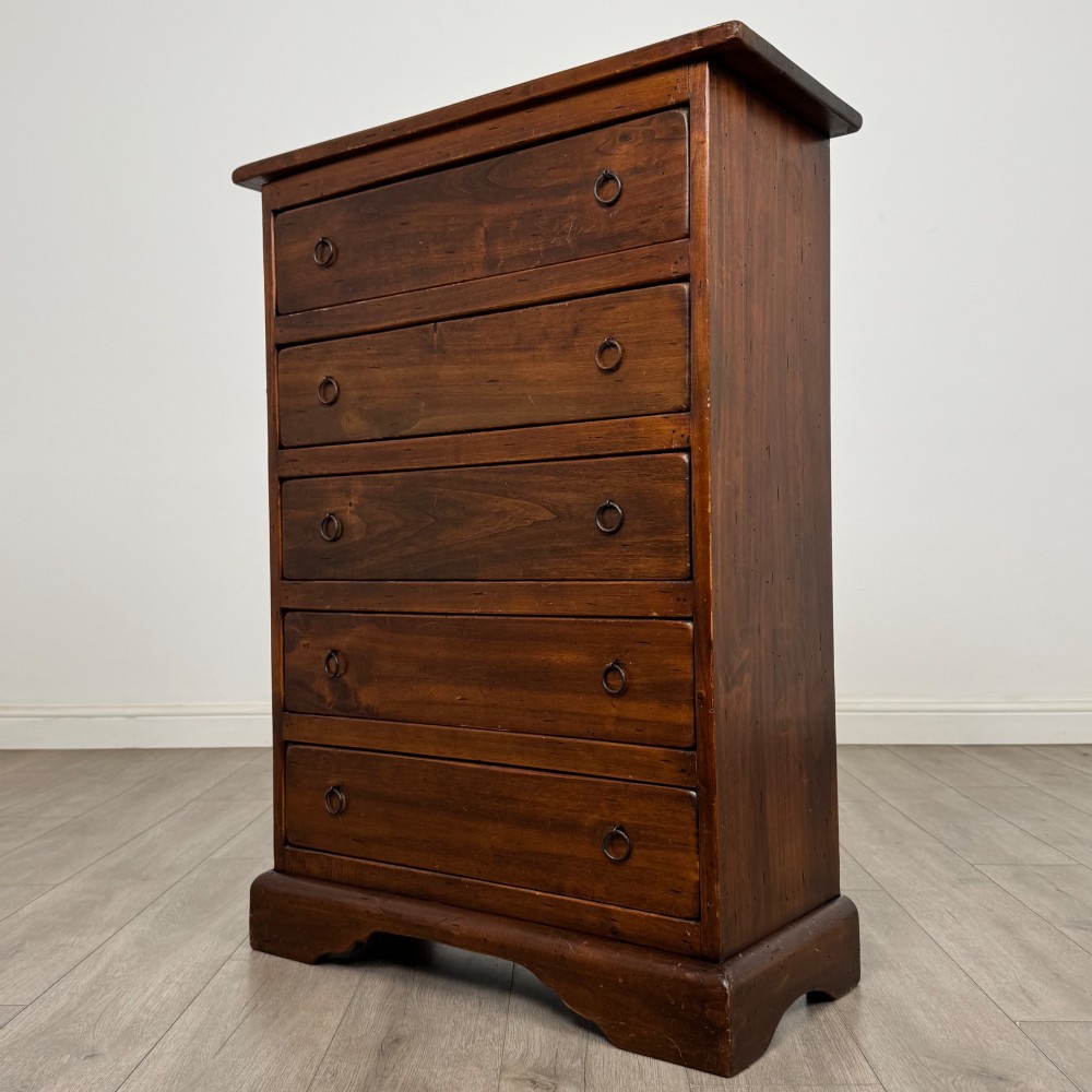 A tall dark brown hardwood chest of drawers featuring five horizontal drawers fitted with metal ring pull handles. View II