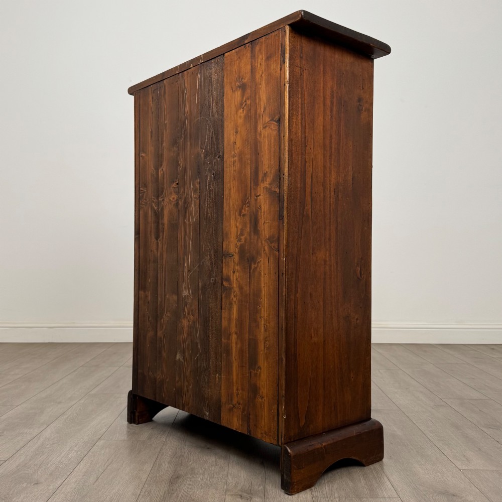 A tall dark brown hardwood chest of drawers featuring five horizontal drawers fitted with metal ring pull handles. View VI