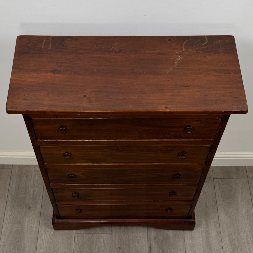 A tall dark brown hardwood chest of drawers featuring five horizontal drawers fitted with metal ring pull handles. View IX