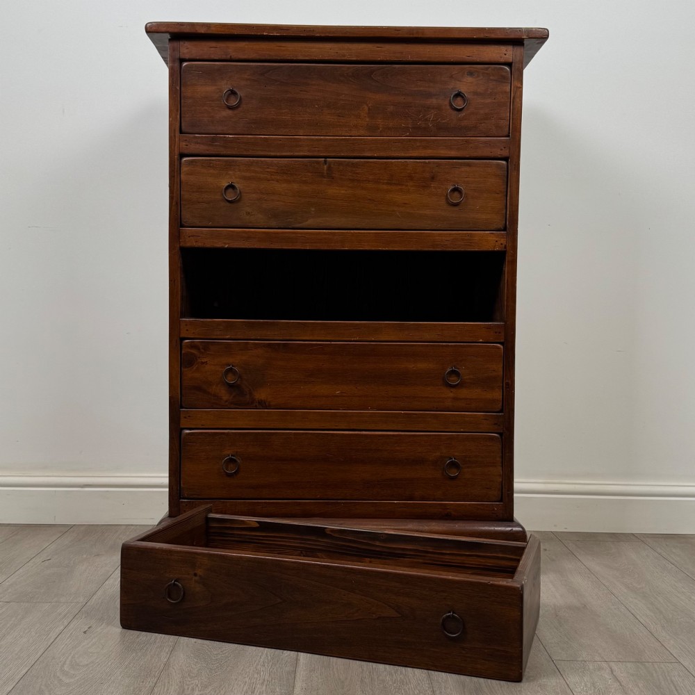 A tall dark brown hardwood chest of drawers featuring five horizontal drawers fitted with metal ring pull handles. View X
