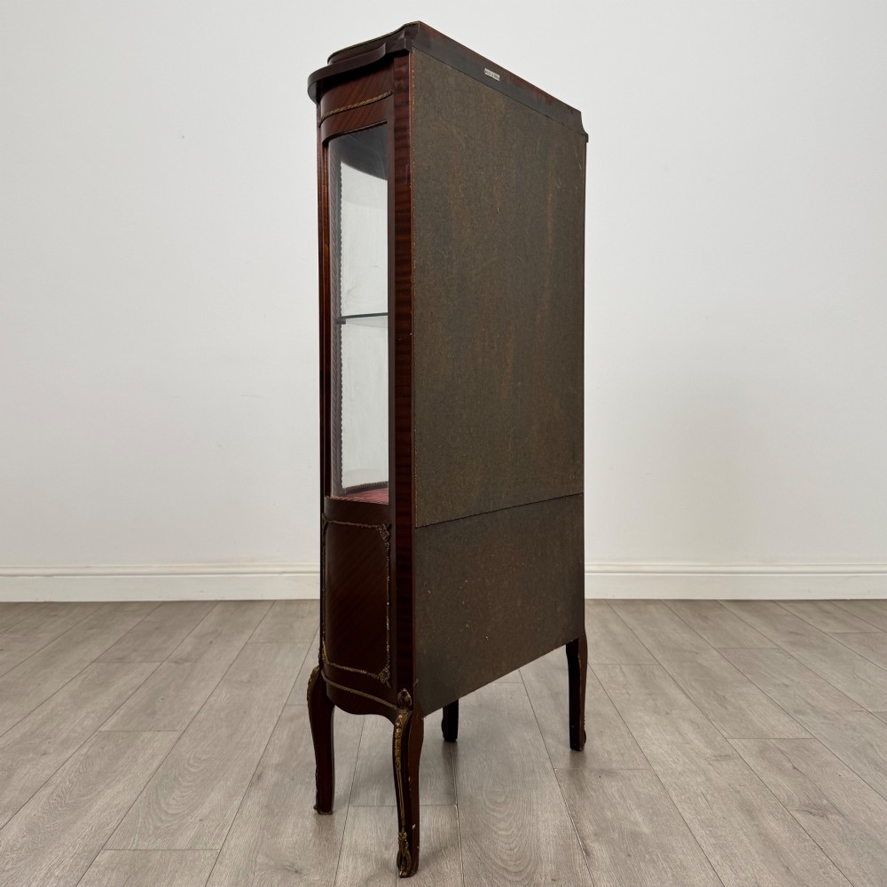 A French mahogany display vitrine featuring a curved glass door, red fabric interior lining, floral marquetry lower panel, and brass leg mounts. View V