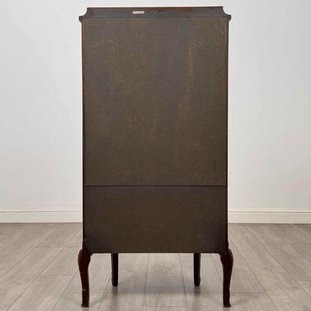 A French mahogany display vitrine featuring a curved glass door, red fabric interior lining, floral marquetry lower panel, and brass leg mounts. View VI