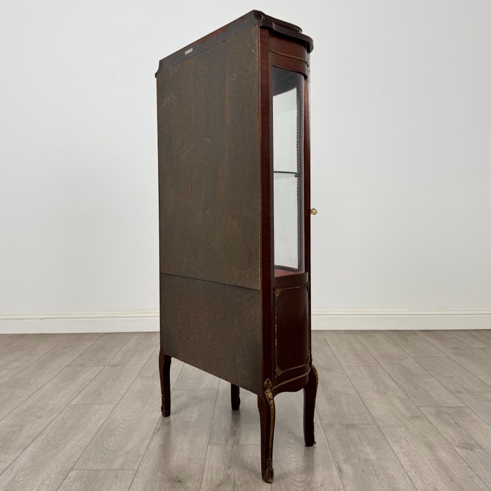 A French mahogany display vitrine featuring a curved glass door, red fabric interior lining, floral marquetry lower panel, and brass leg mounts. View VII
