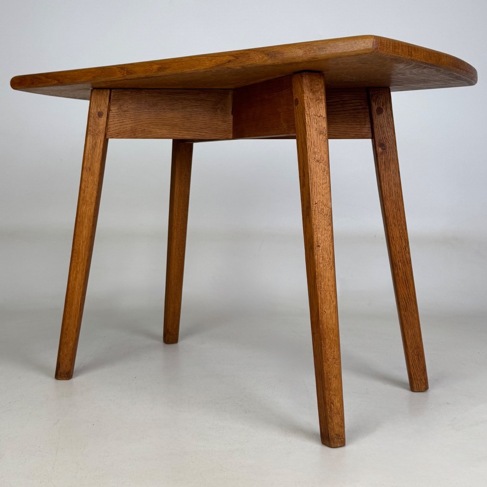 A rectangular golden oak coffee table with tapered splayed legs and visible wooden peg joinery. View II
