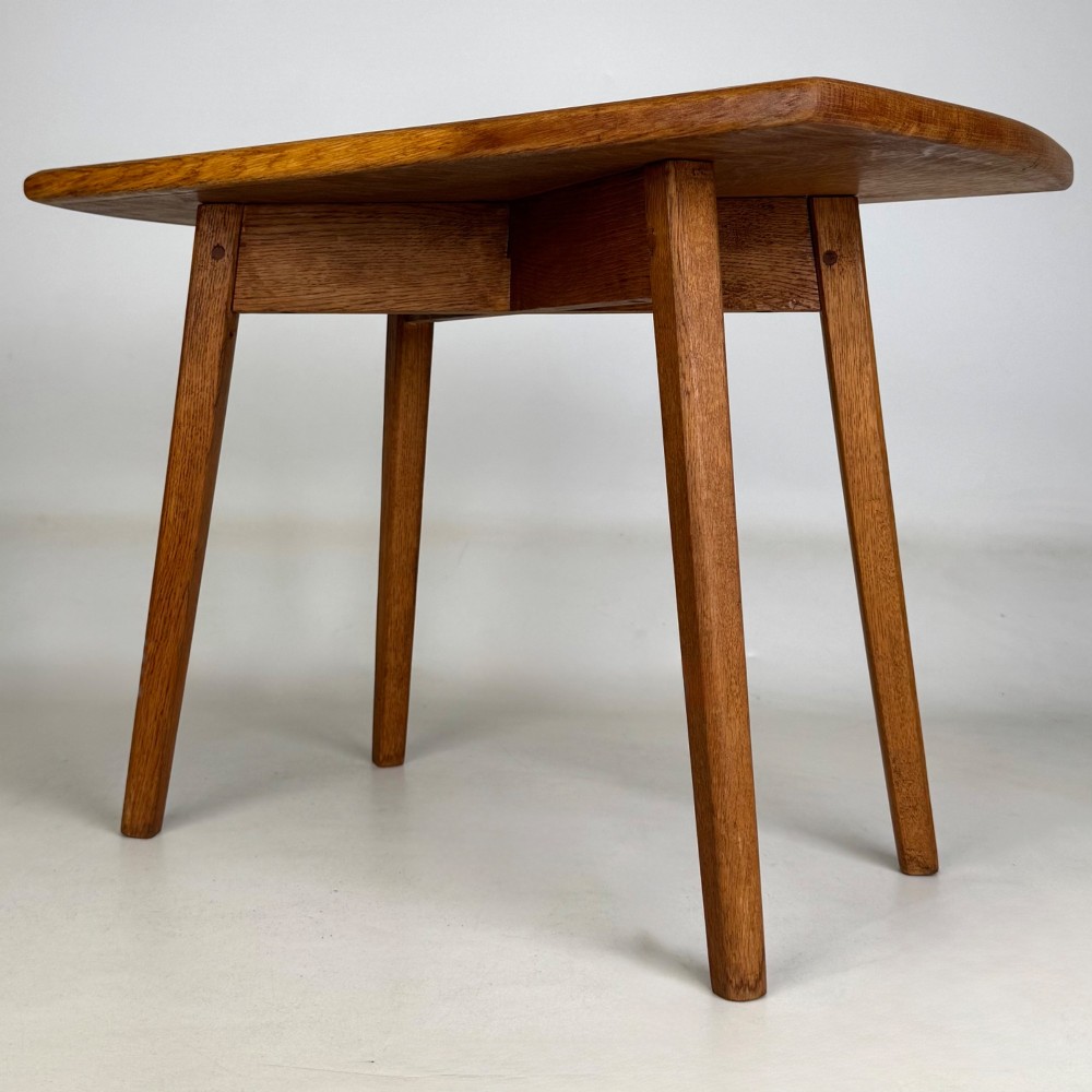 A rectangular golden oak coffee table with tapered splayed legs and visible wooden peg joinery. View VI