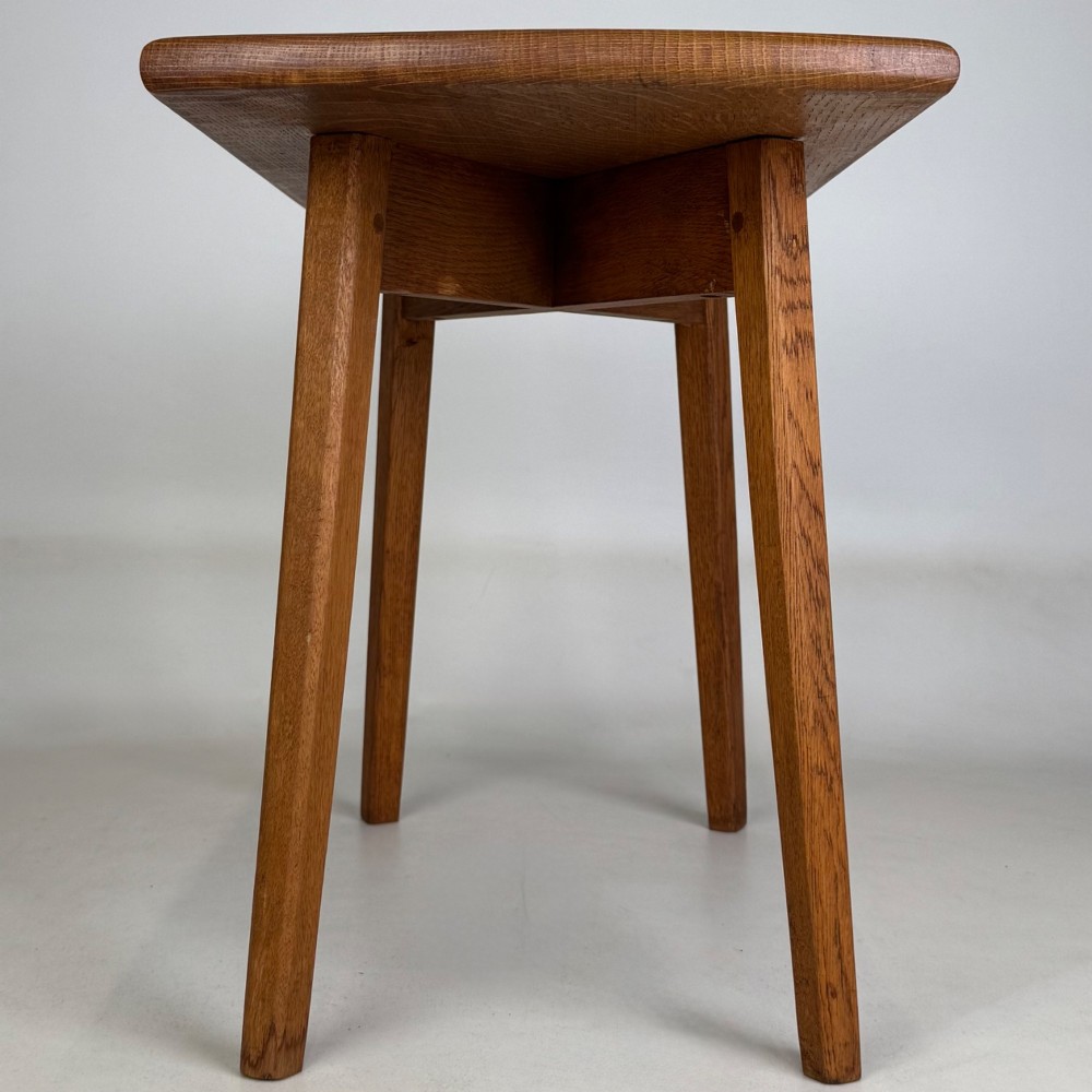 A rectangular golden oak coffee table with tapered splayed legs and visible wooden peg joinery. View VII