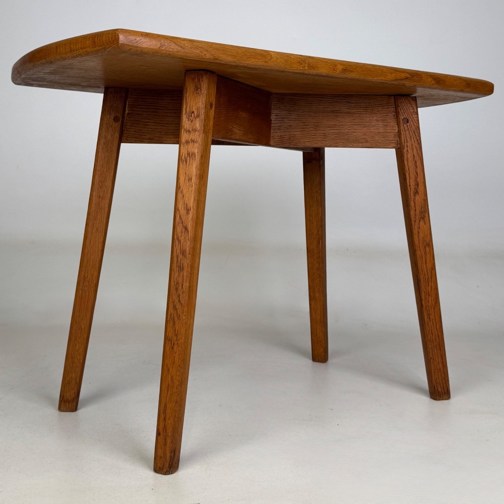 A rectangular golden oak coffee table with tapered splayed legs and visible wooden peg joinery. View VIII