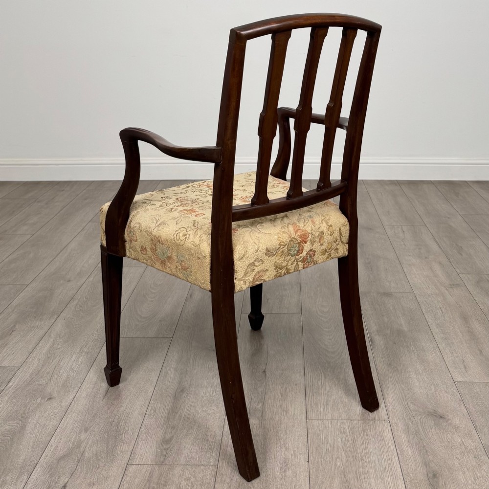 A set of six dark mahogany dining chairs featuring carved vertical back splats, square tapered legs, and floral upholstered seats. View III