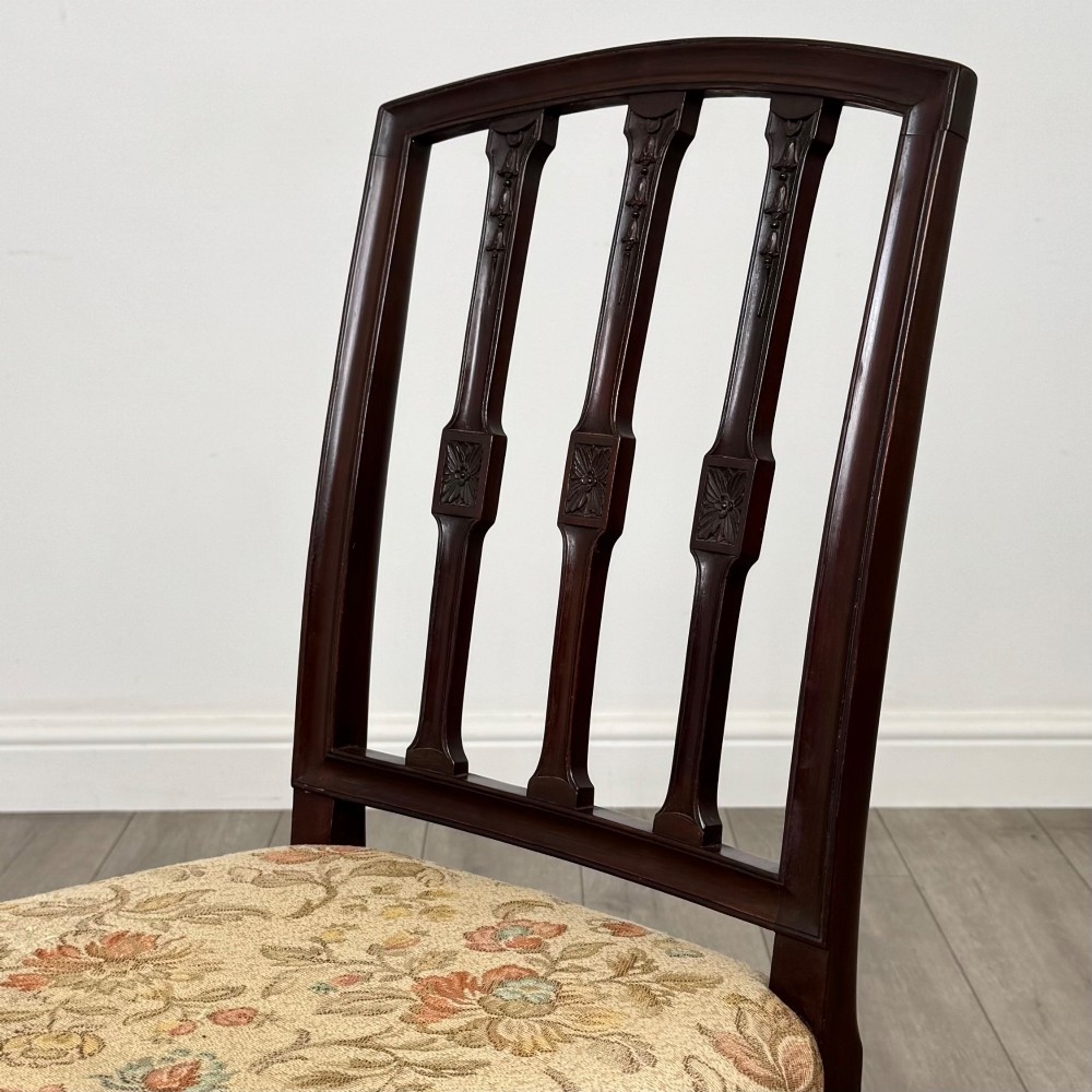 A set of six dark mahogany dining chairs featuring carved vertical back splats, square tapered legs, and floral upholstered seats. View VI
