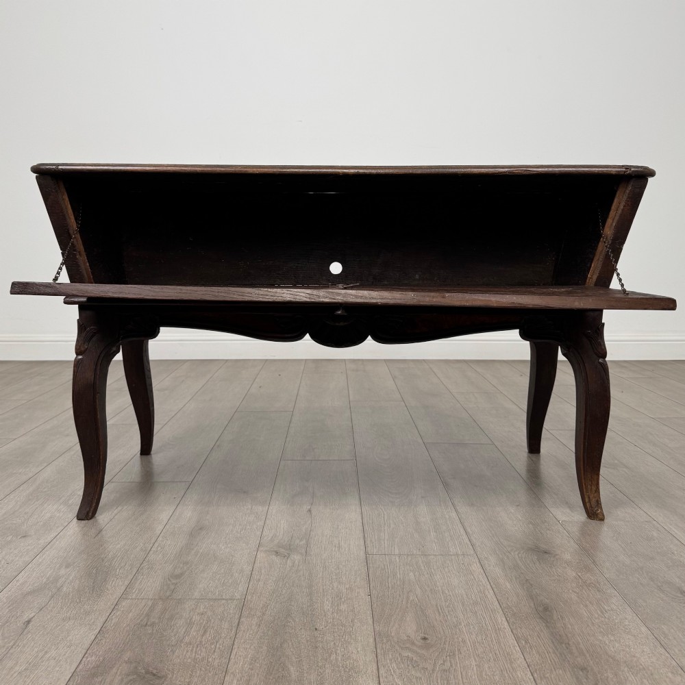 A nineteenth-century French provincial walnut dough bin featuring hand-carved central cartouche ornamentation and shaped cabriole legs. View II