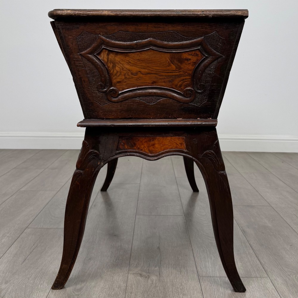 A nineteenth-century French provincial walnut dough bin featuring hand-carved central cartouche ornamentation and shaped cabriole legs. View III