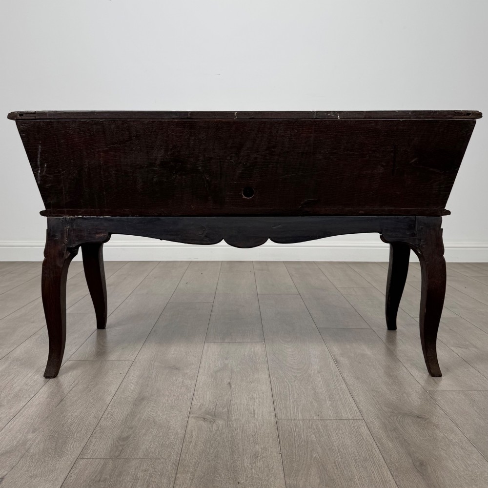 A nineteenth-century French provincial walnut dough bin featuring hand-carved central cartouche ornamentation and shaped cabriole legs. View V