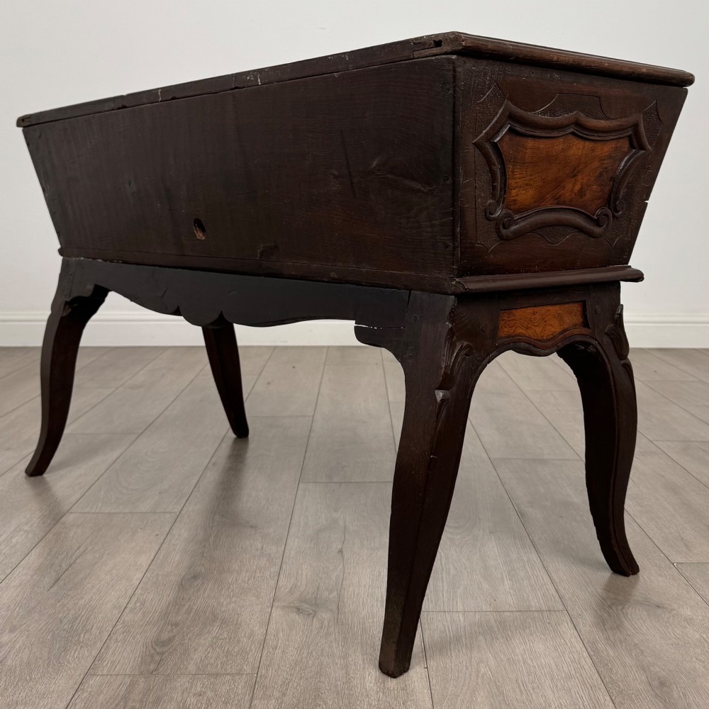 A nineteenth-century French provincial walnut dough bin featuring hand-carved central cartouche ornamentation and shaped cabriole legs. View VI