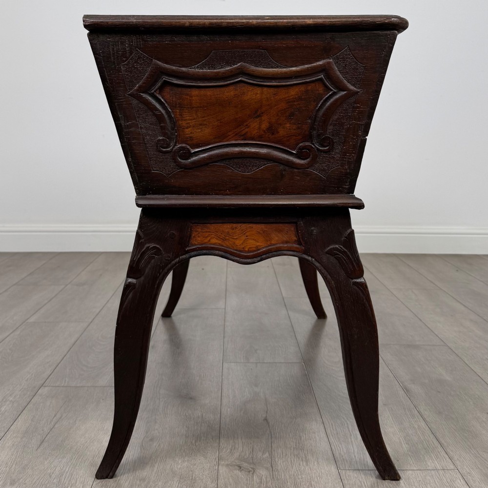 A nineteenth-century French provincial walnut dough bin featuring hand-carved central cartouche ornamentation and shaped cabriole legs. View VII